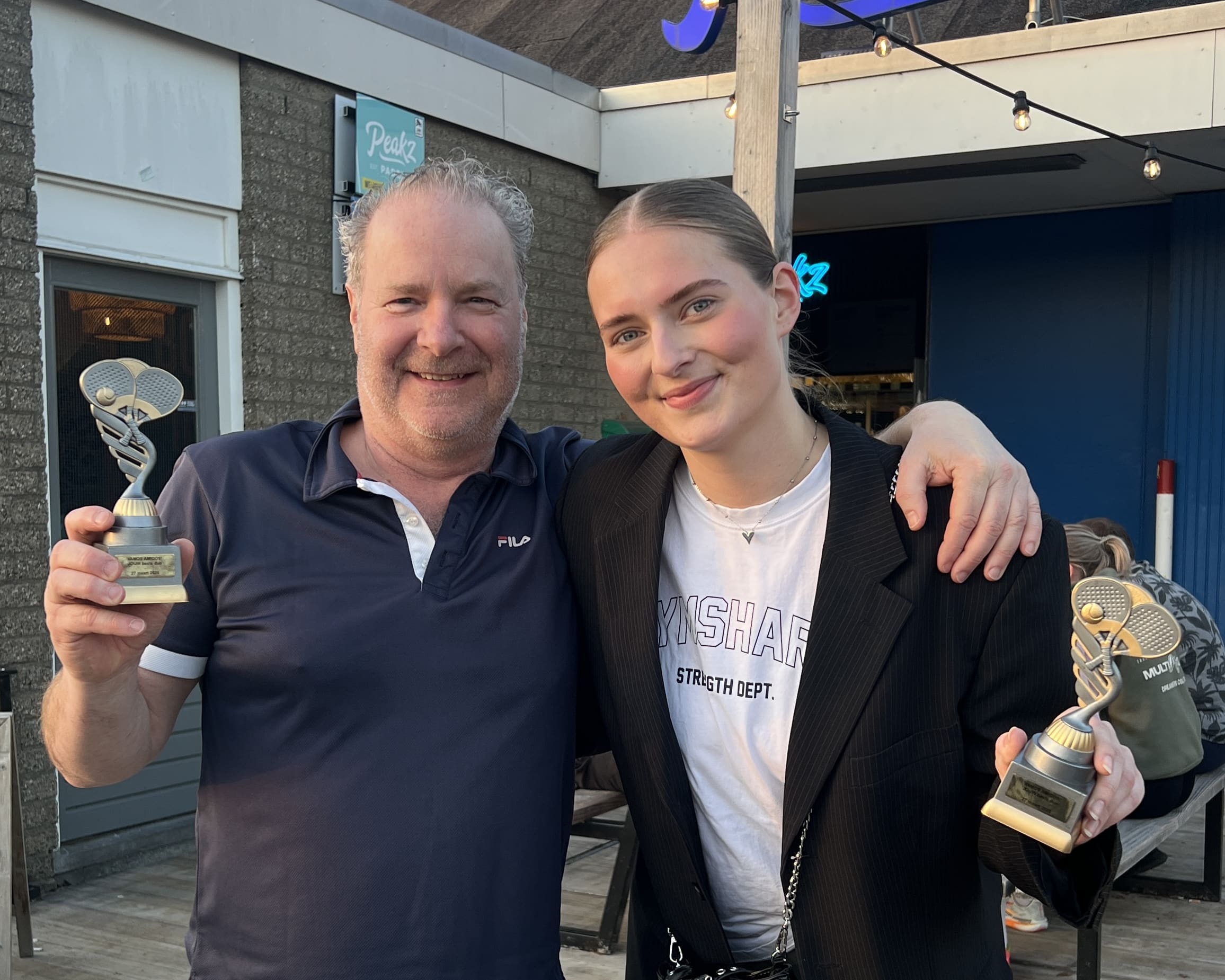 Sophie en Joep als eerlijke winnaar voor het Peakz Padel gebouw. Beiden met een welverdiende beker.